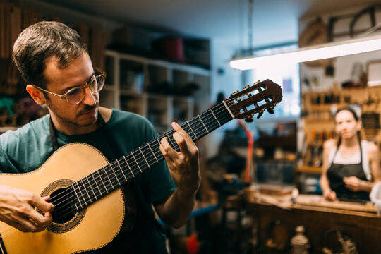 Luthier playing a spanish guitar to check the tuning and sound
