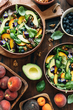 Peach salad with avocado, blueberries, walnuts and pansy flowers