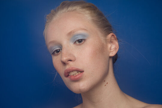 Young freckled model with blue eyeshadows