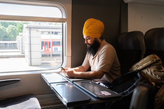 Man With Turban In The Train Using Cellphone