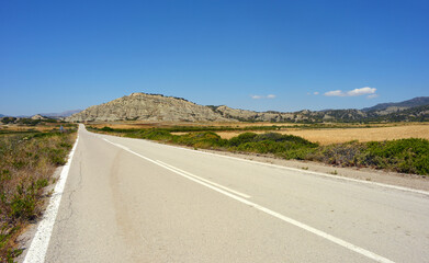Lonely road with no cars but beautiful landscape in Rhodes Island, Greece
