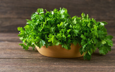 fresh parsley in a wooden bowl on the table, selective focus, rustic style.