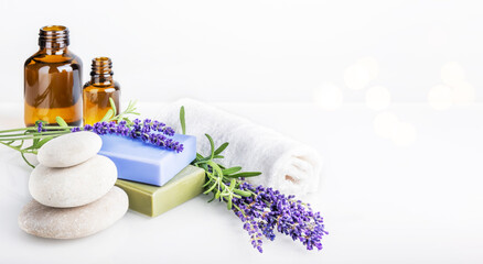 Spa and body care, aromatherapy and essential oil, herbal eco-friendly cosmetics concept. Natural homemade soap bars, glass bottles with massage oil and bunch of lavender flowers on white background.
