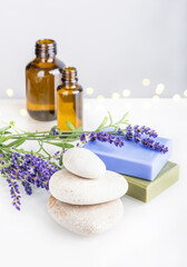 Obraz na płótnie Canvas Spa and body care, aromatherapy and essential oil, herbal eco-friendly cosmetics concept. Natural homemade soap bars, glass bottles with massage oil and bunch of lavender flowers on white background.