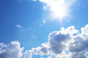 The bright scorching sun and cumulus clouds. Background. Scenery. - obrazy, fototapety, plakaty