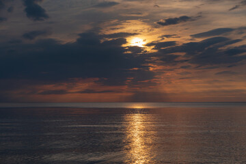 sunset in the sea with clouds and calm water