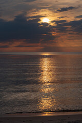 Fototapeta premium sunset in the sea with clouds and calm water