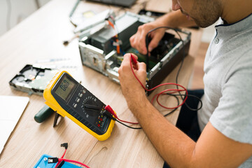 Professional engineer connecting a multimeter to a pc - obrazy, fototapety, plakaty