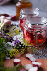 Two Glass Jars with Pickled Radish with greenery, garlic and spices
