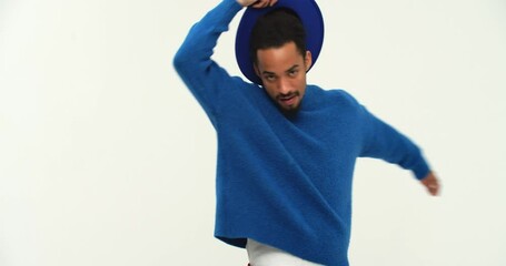 Active joyful black man having fun and take off his blue hat while dancing isolated over white 