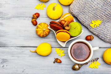 French macarons in autumn colors with cup of hot tea