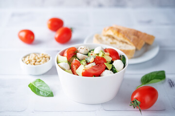 Cucumber tomato avocado mozzarella salad in a bowl