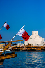 The flag of Qatar with a background of Museum of Islamic Art