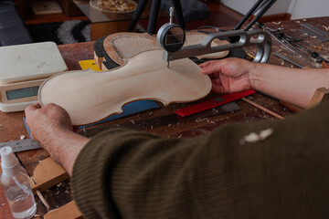 Luthier take measures to get better the violin body