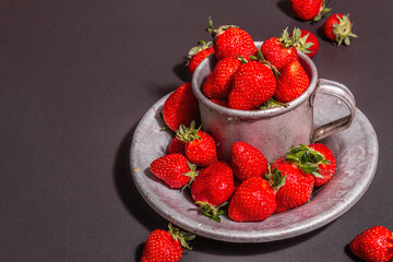 Concept of summer food with a strawberry on a black stone background