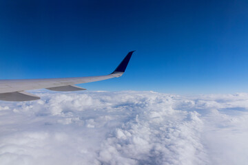 Obraz premium Wing aircraft in altitude during flying above the clouds