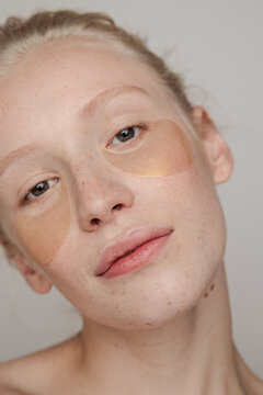Young freckled model with golden under-eye patches
