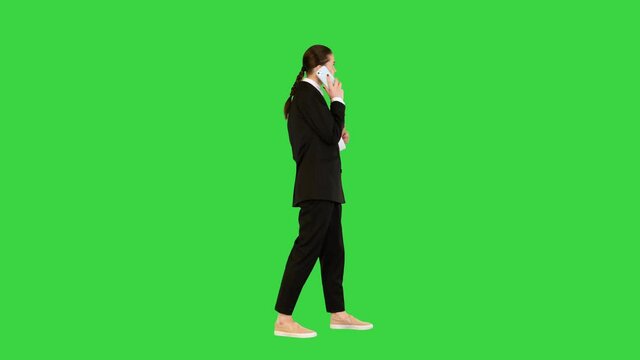 Young female office worker talking on mobile phone, smiling on a Green Screen, Chroma Key.