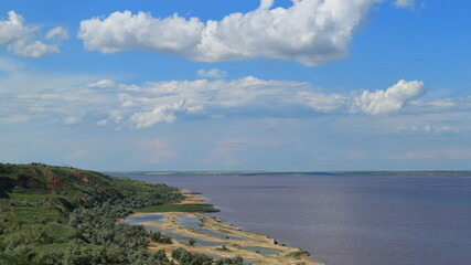 The beautiful landscape of the lake from a steep cliff with blue skies, white clouds and pink water is created by blooming microorganisms.