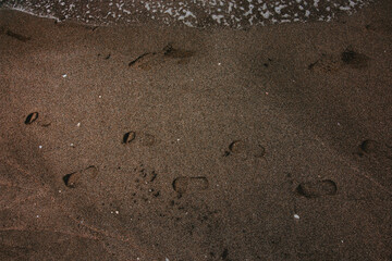 Traces of man on the sand along the sea