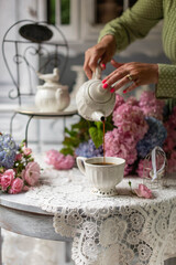 Still-Life with purple and pink Hortensia flowers, breakfast table setting.