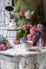 Fototapeta na wymiar Still-Life with purple and pink Hortensia flowers, breakfast table setting.