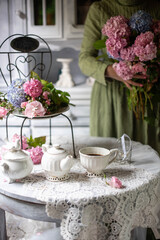 Still-Life with purple and pink Hortensia flowers, breakfast table setting.