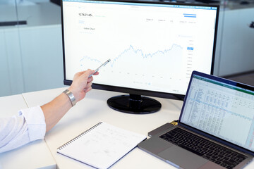 Stock broker businessman analyzing graphs and charts and talking by phone