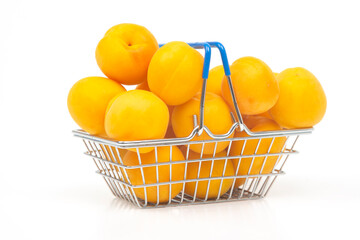 Ripe apricots in a grocery basket from a supermarket on a white background