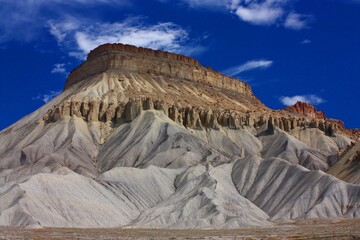 the dramatically-eroded cliffs  of mount garfield against a blue sky, grand junction, colorado