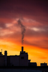Fum&eacute;e de chemin&eacute;e dans le ciel au couch&eacute; du soleil