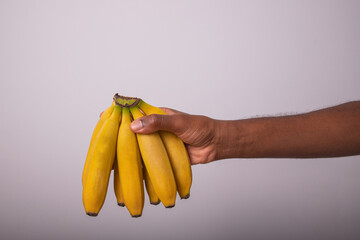 a bunch of bananas held by a man. Appetizing bananas isolated on white background