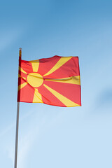 North Macedonian flag waving in wind. Flag of North Macedonia on blue sky background.