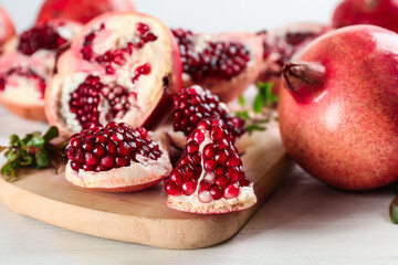Delicious ripe pomegranates on white wooden table, closeup