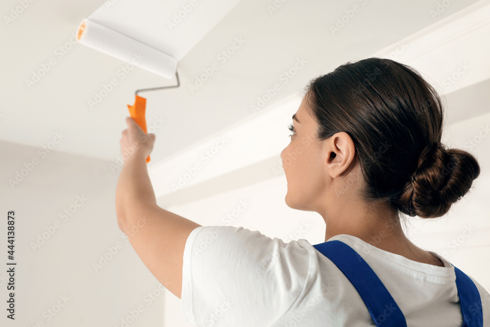 Poster Worker painting ceiling with white dye indoors