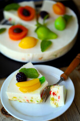 White soufflé cake with marmalade fruits.