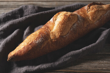 Cloth and baguette set against an old wooden background