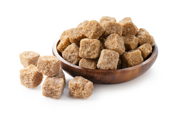 Brown sugar cubes on a wooden plate set against a white background.