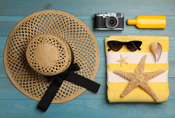 Flat lay composition with beach objects on light blue wooden background