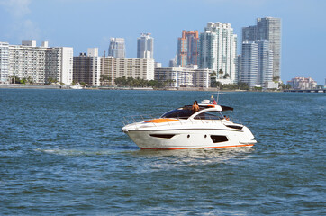 High-end cabin cruiser idling on the Florida Intra-Coastal Waterway with condominium apartment...
