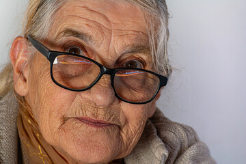 mujer mayor mirando de reojo sobre sus lentes 