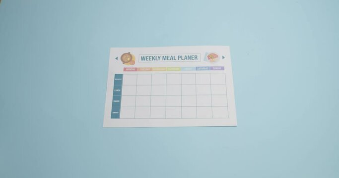 Blank meal plan and different products on color background, video with stop motion effect