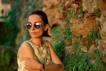 stylish girl in a yellow dress and sunglasses in the park
