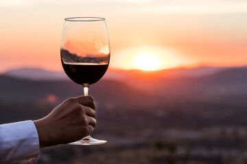 Glass of wine under sunset on the mountain
