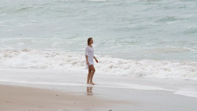 Young woman walks along the beach - extreme slow motion - people photography