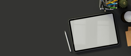 Digital tablet with mock-up screen on dark table with supplies and copy space, 3D render