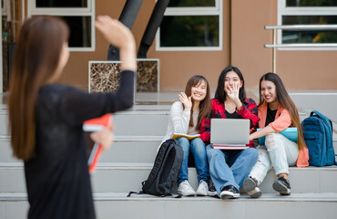 Blurry young attractive asian girls college students waving goodbye to friends in university campus...