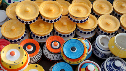 Collection of colorful pots and vases and also plates and bowls  in market for selling