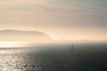 Fototapeta premium Sailboat in the misty islands at dusk