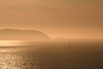 Naklejka na ściany i meble Sailboat in the misty islands at dusk